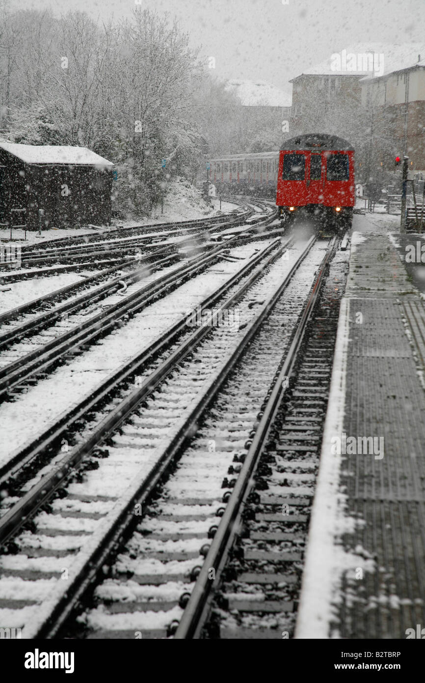District Line train comes into a snowy East Putney tube station, London Stock Photo