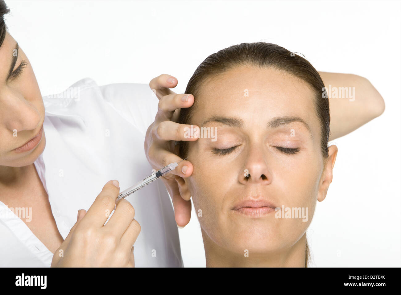 Woman receiving Botox injection, eyes closed Stock Photo
