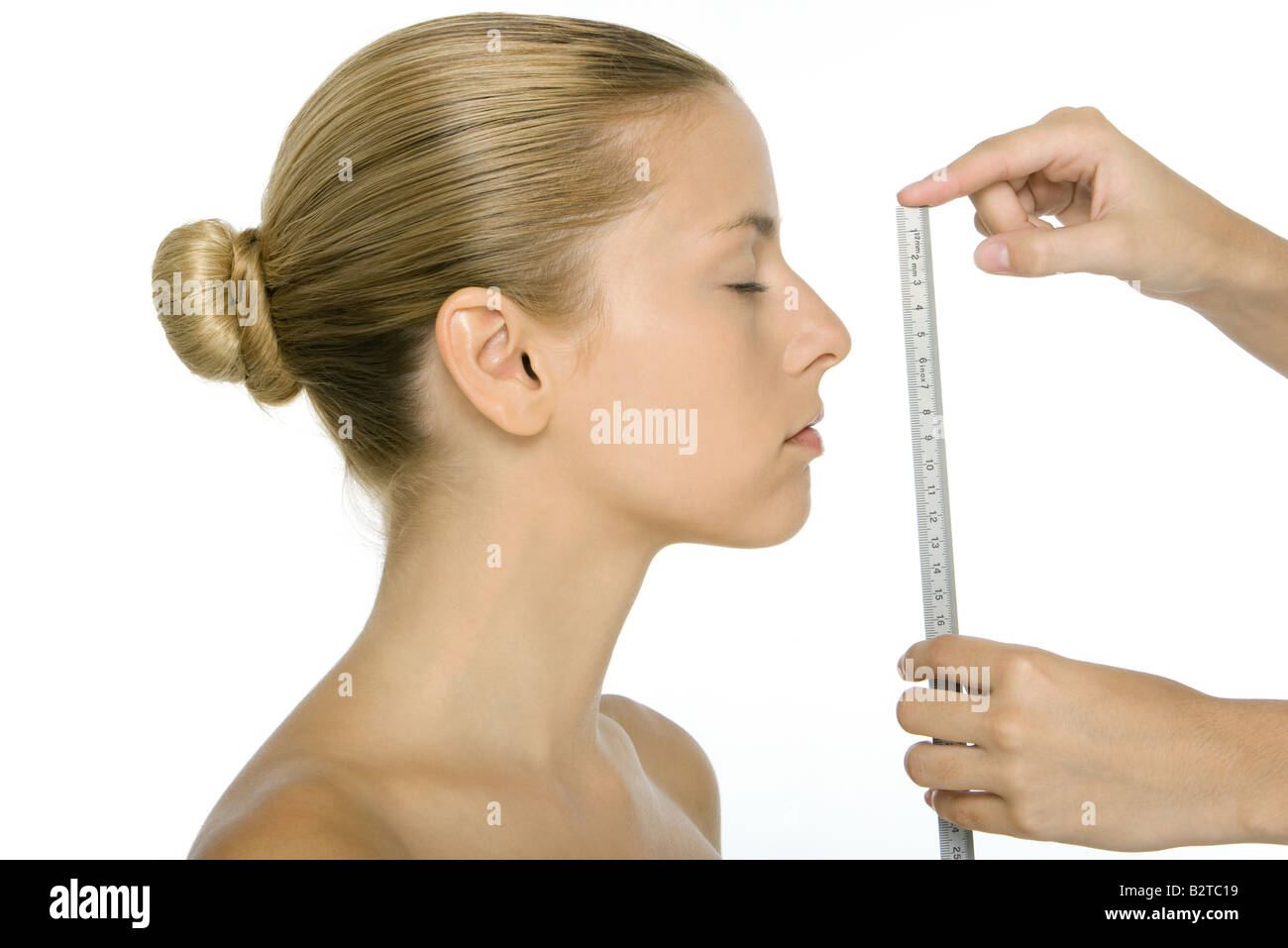 Woman in profile, face being measured with ruler Stock Photo