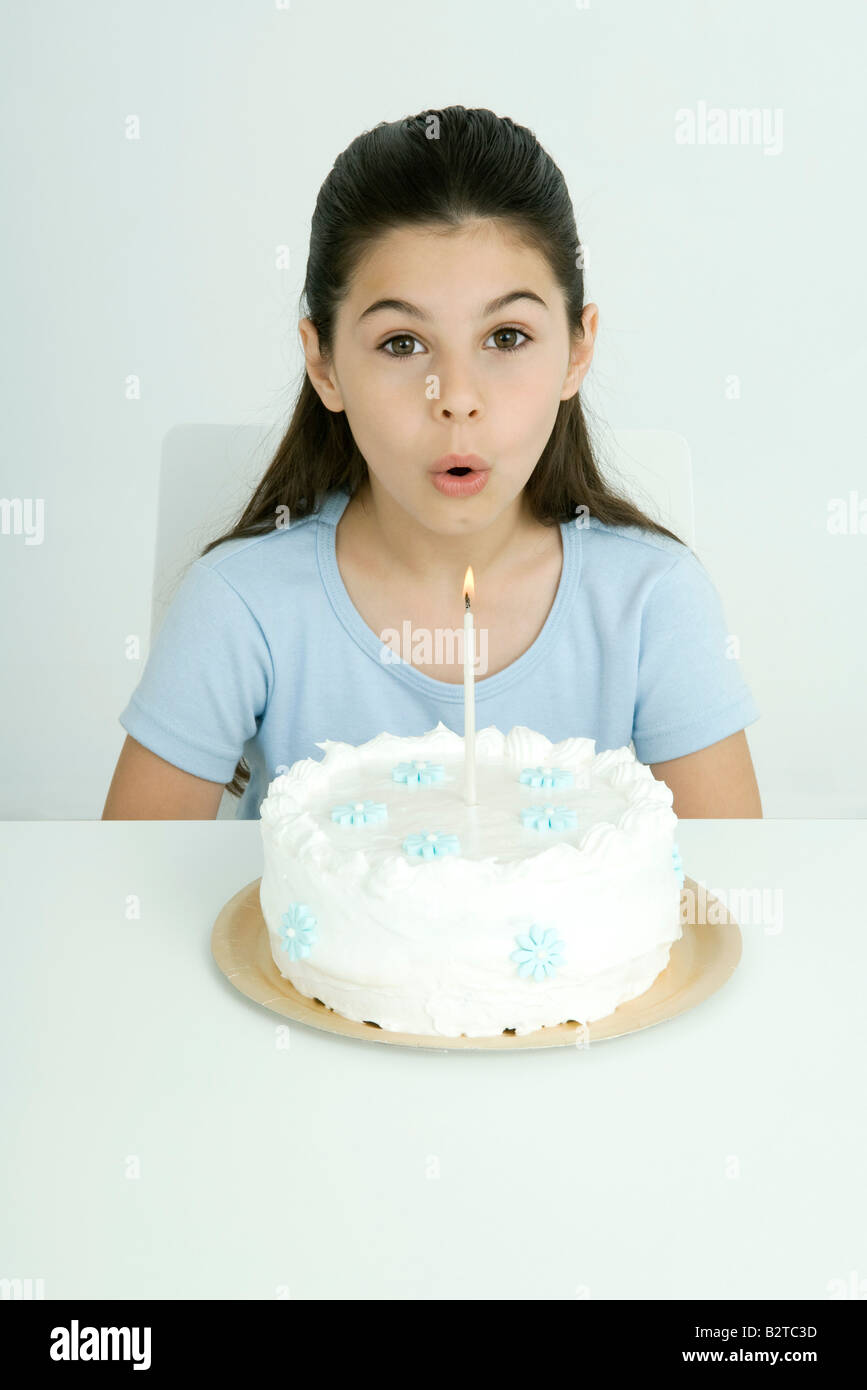 Girl blowing out candle on birthday cake, portrait Stock Photo