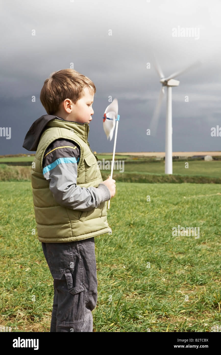 Boy blowing windmill on a wind farm Stock Photo