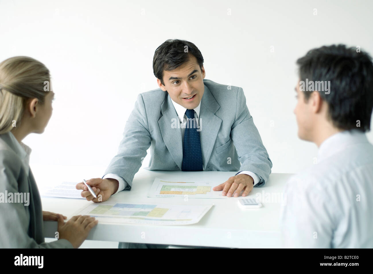 Professional explaining blueprints to clients Stock Photo - Alamy