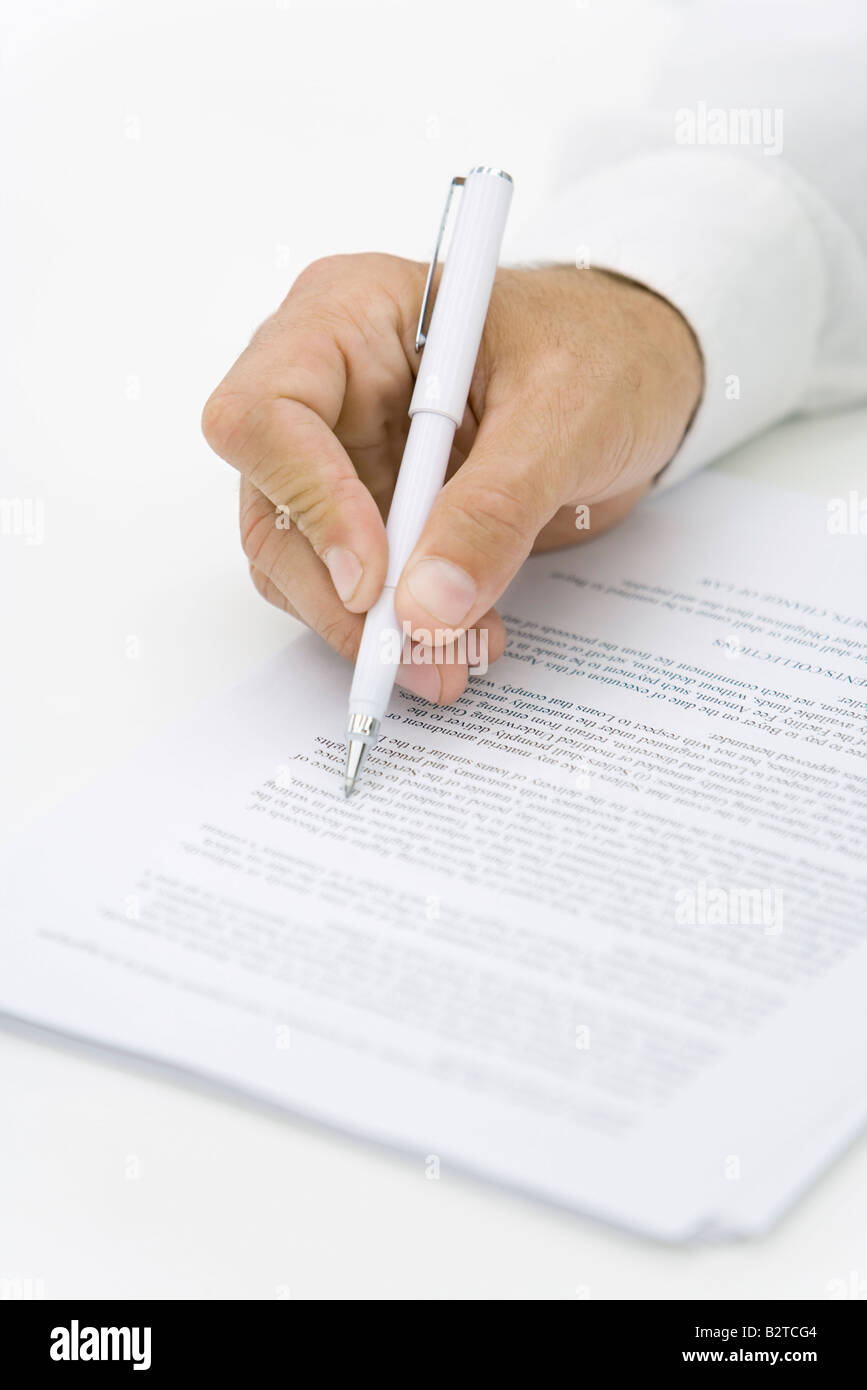 Businessman reviewing contract with pen, cropped view of hand Stock Photo