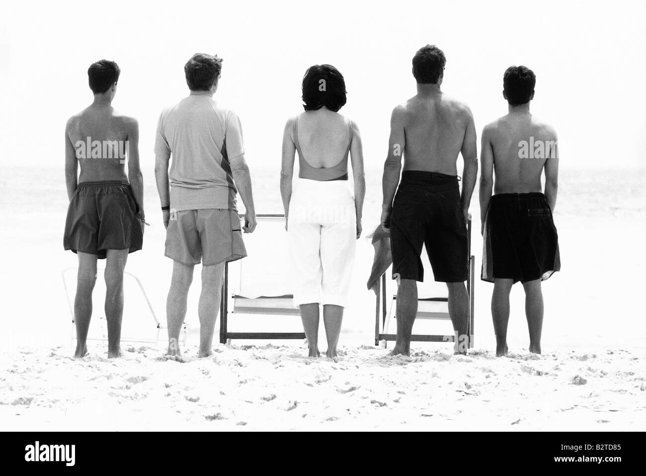 Family standing side by side at the beach, rear view Stock Photo
