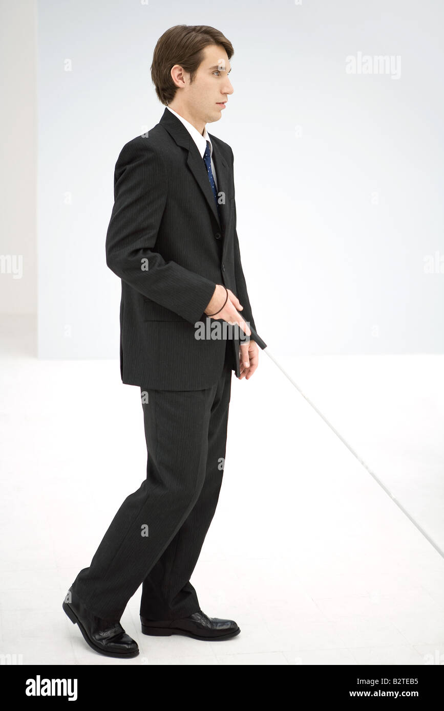 Businessman walking with white cane, side view Stock Photo - Alamy