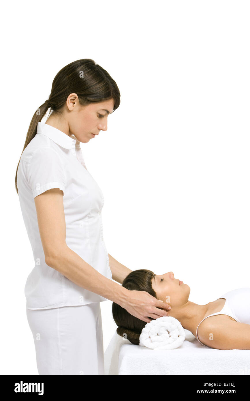 Massage therapist performing head massage, side view Stock Photo Alamy