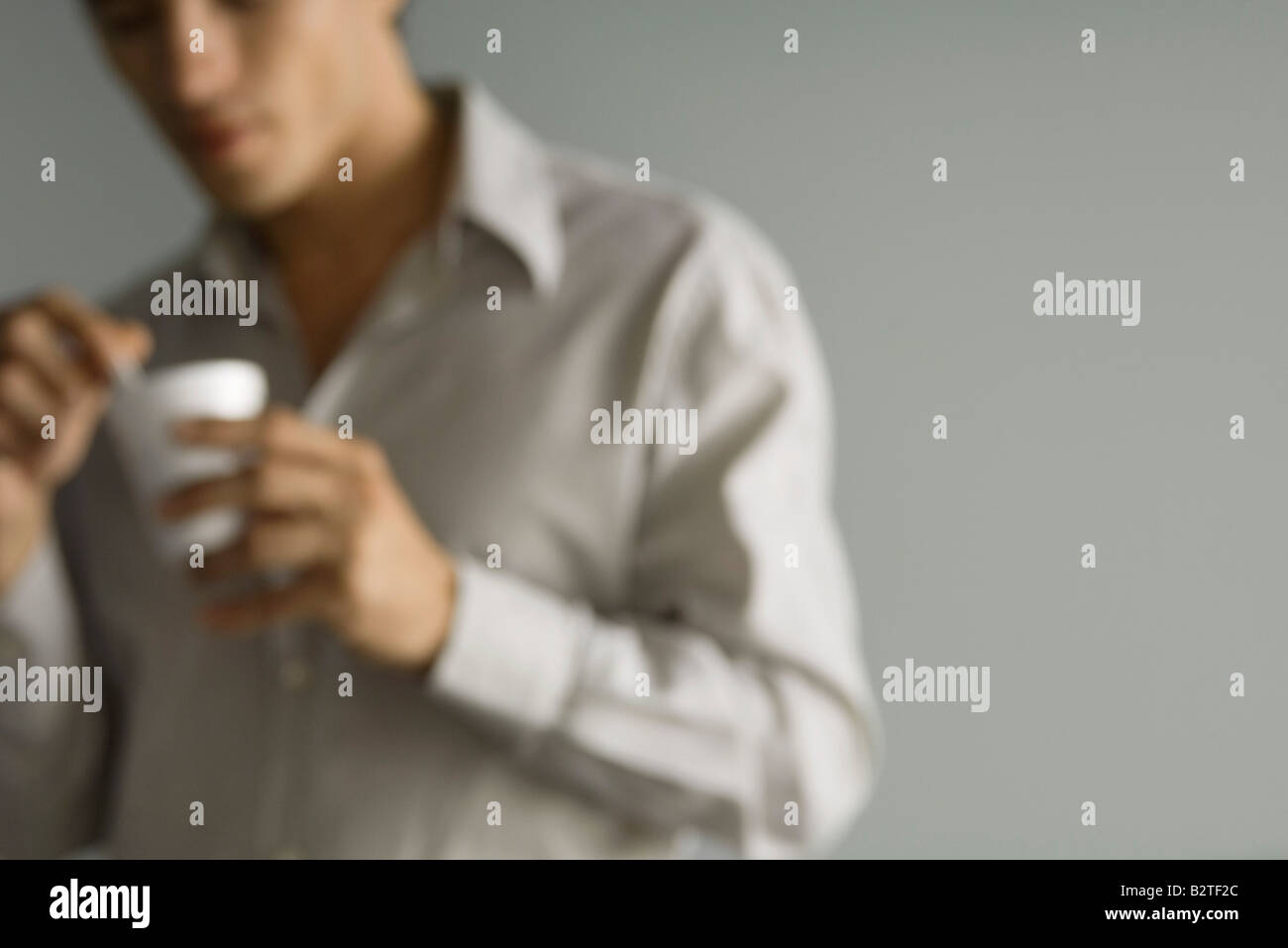 Man holding disposable coffee cup, defocused, cropped Stock Photo