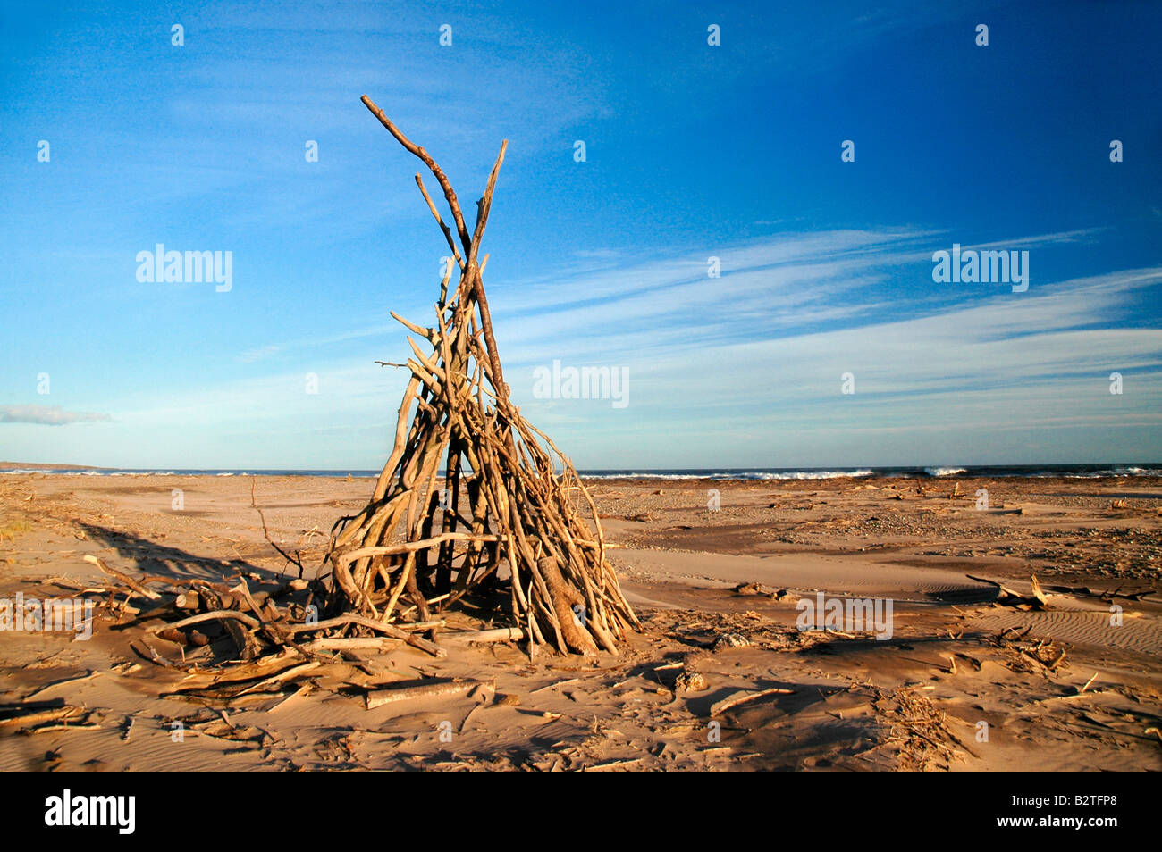Tepee like sculpting on a beach, made with the use of drift wood. Stock Photo