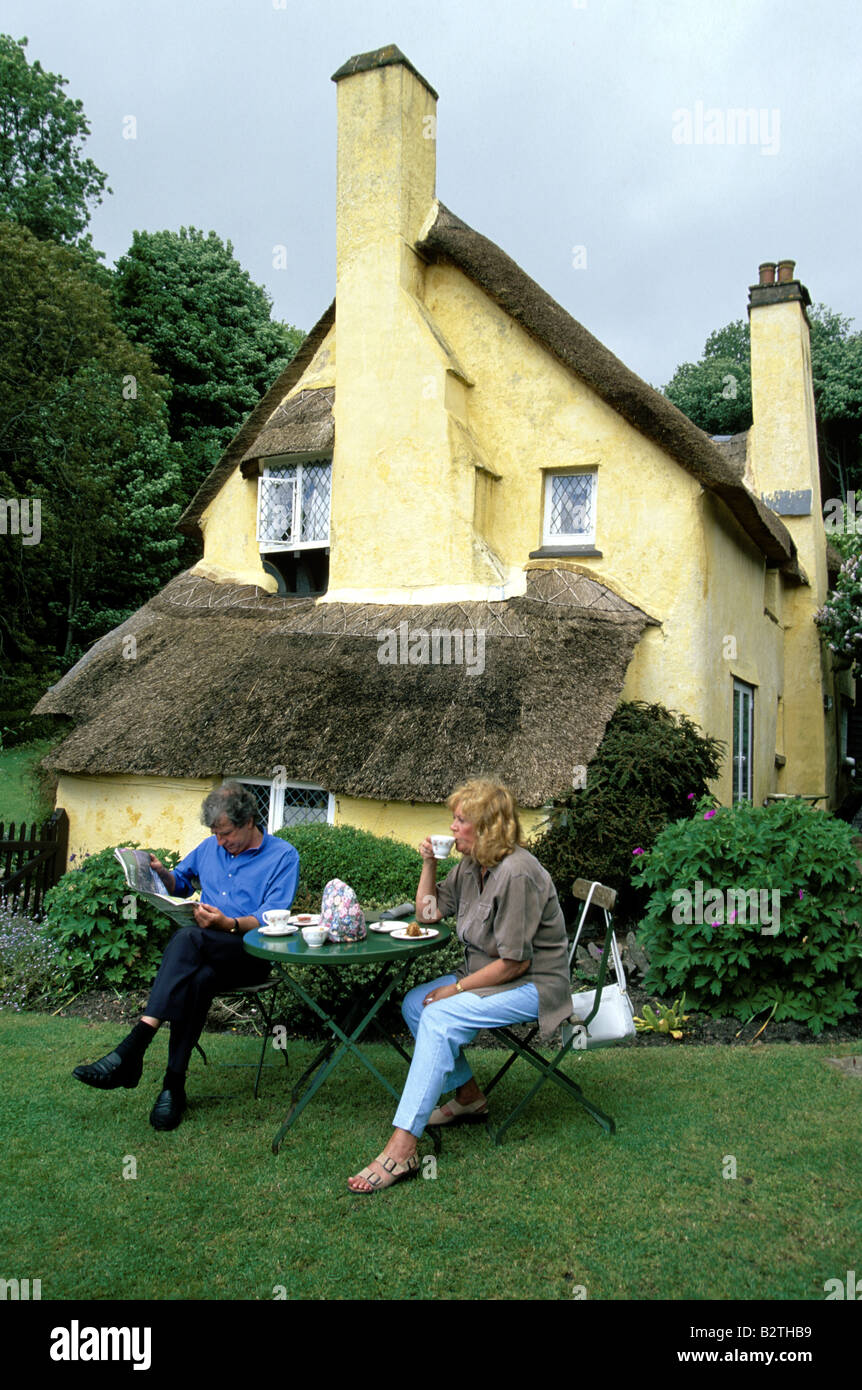 A couple sitting outside a cafe in a thatched house in Selworthy, Somerset Stock Photo