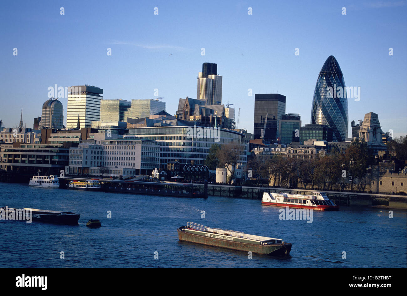 View over River Thames and pleasure boats to the Tower and City of London, including the Swiss Re Building. Stock Photo