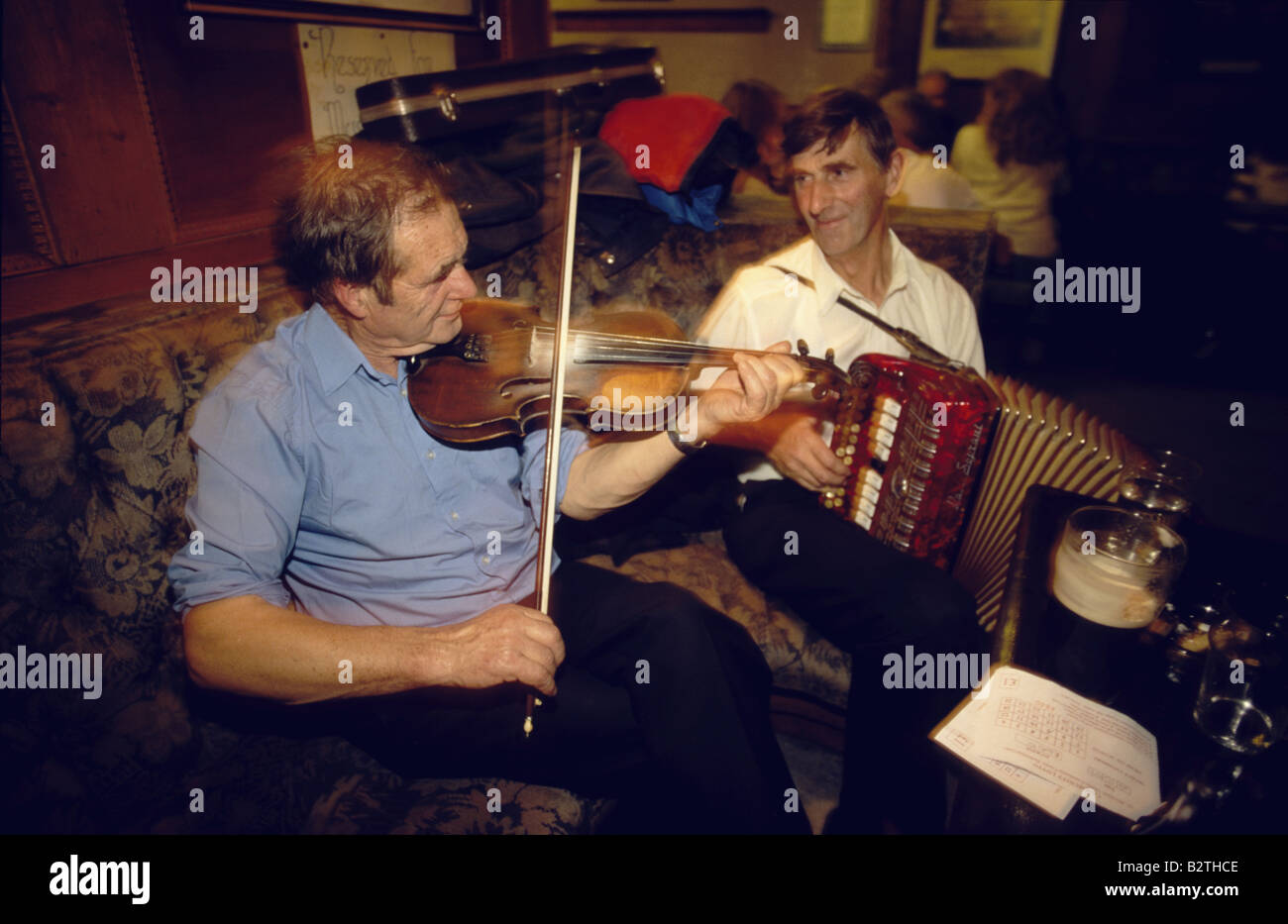 Two men playing traditional music on violin and accordion in Gus O'Connor's Pub, Doolin, County Clare, Ireland Stock Photo