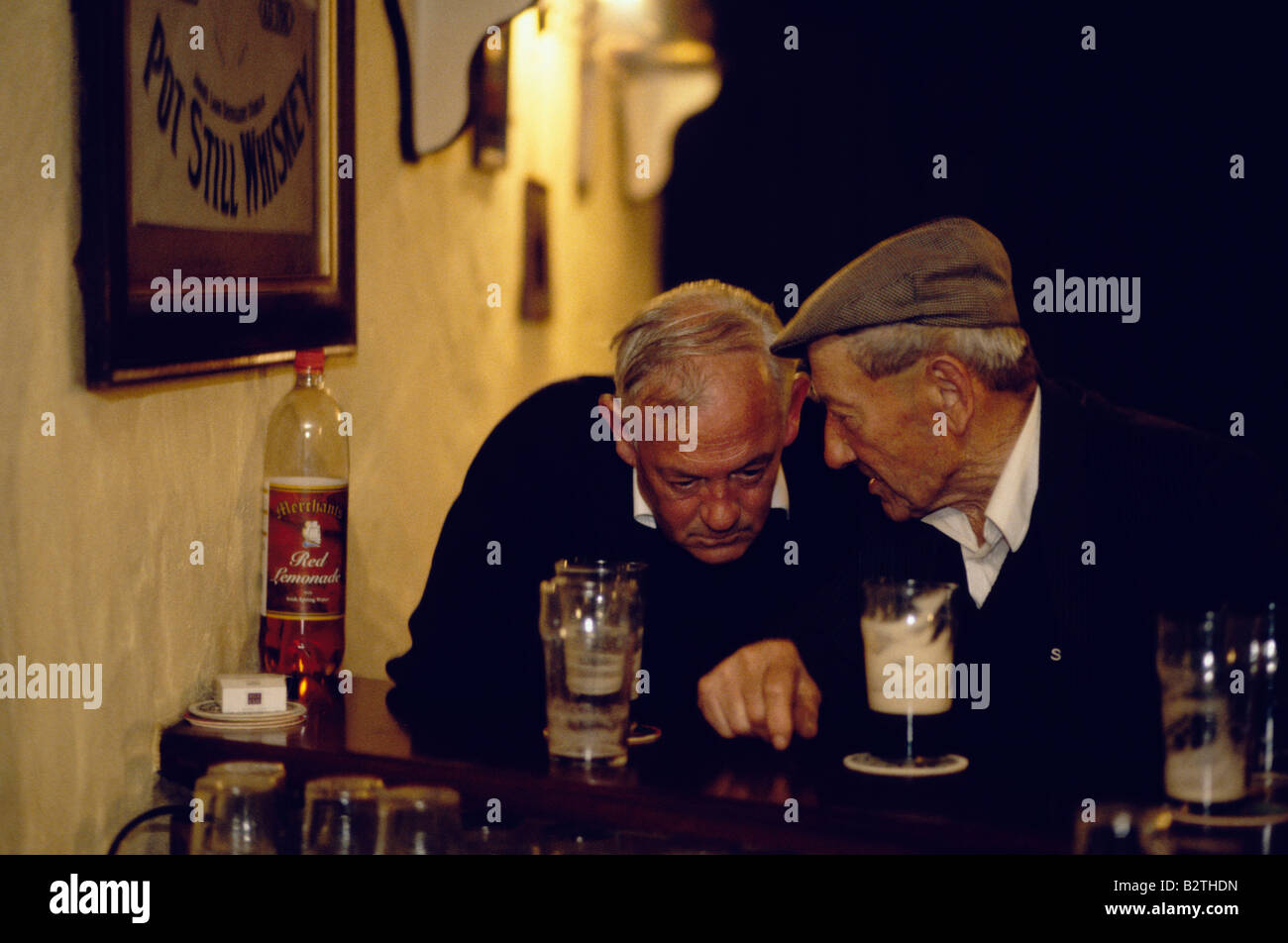 Two old men in discussion at bar having a beer, County Mayo, Ireland Stock Photo