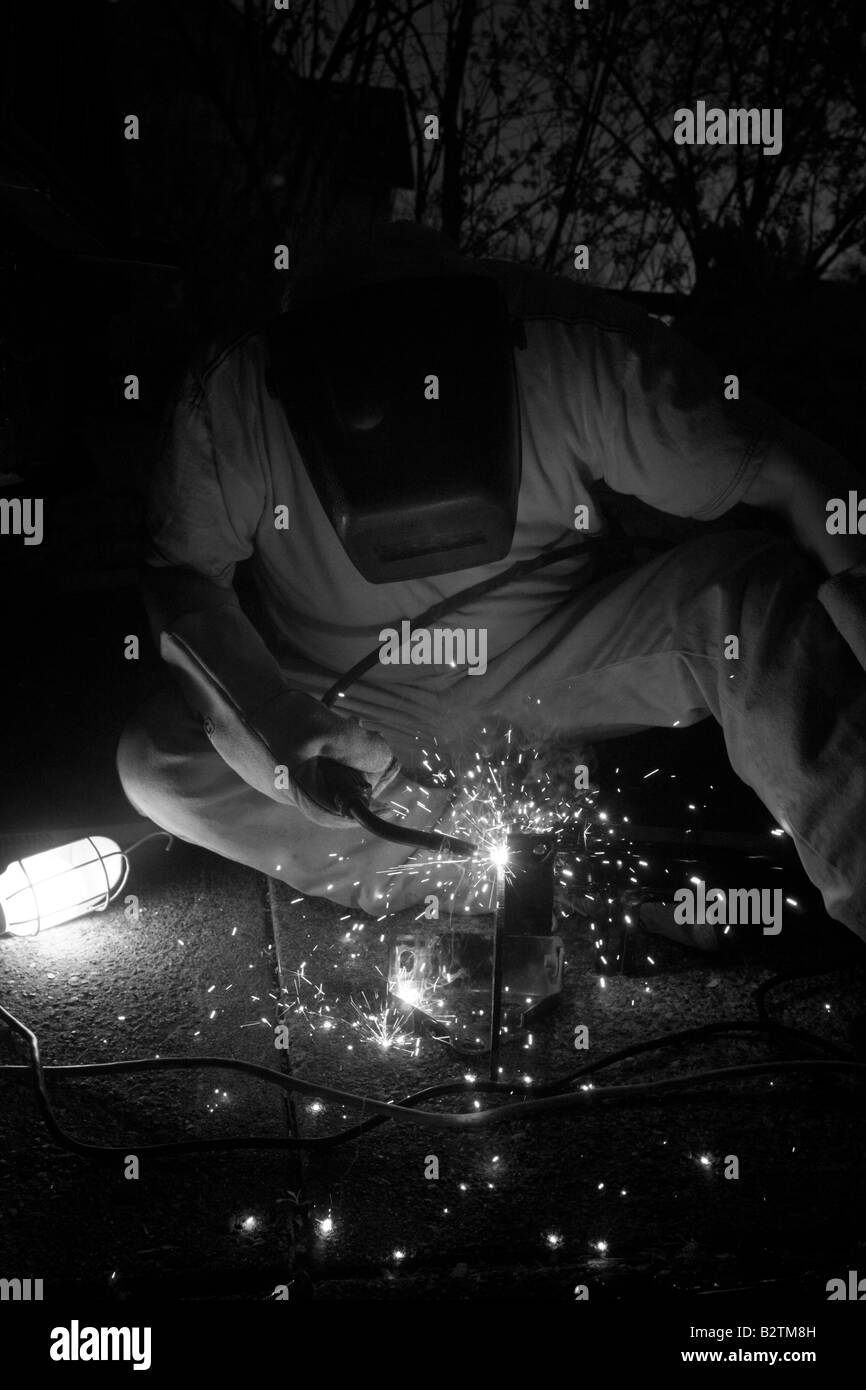 Steel worker uses welding torch, creating sparks Stock Photo Alamy