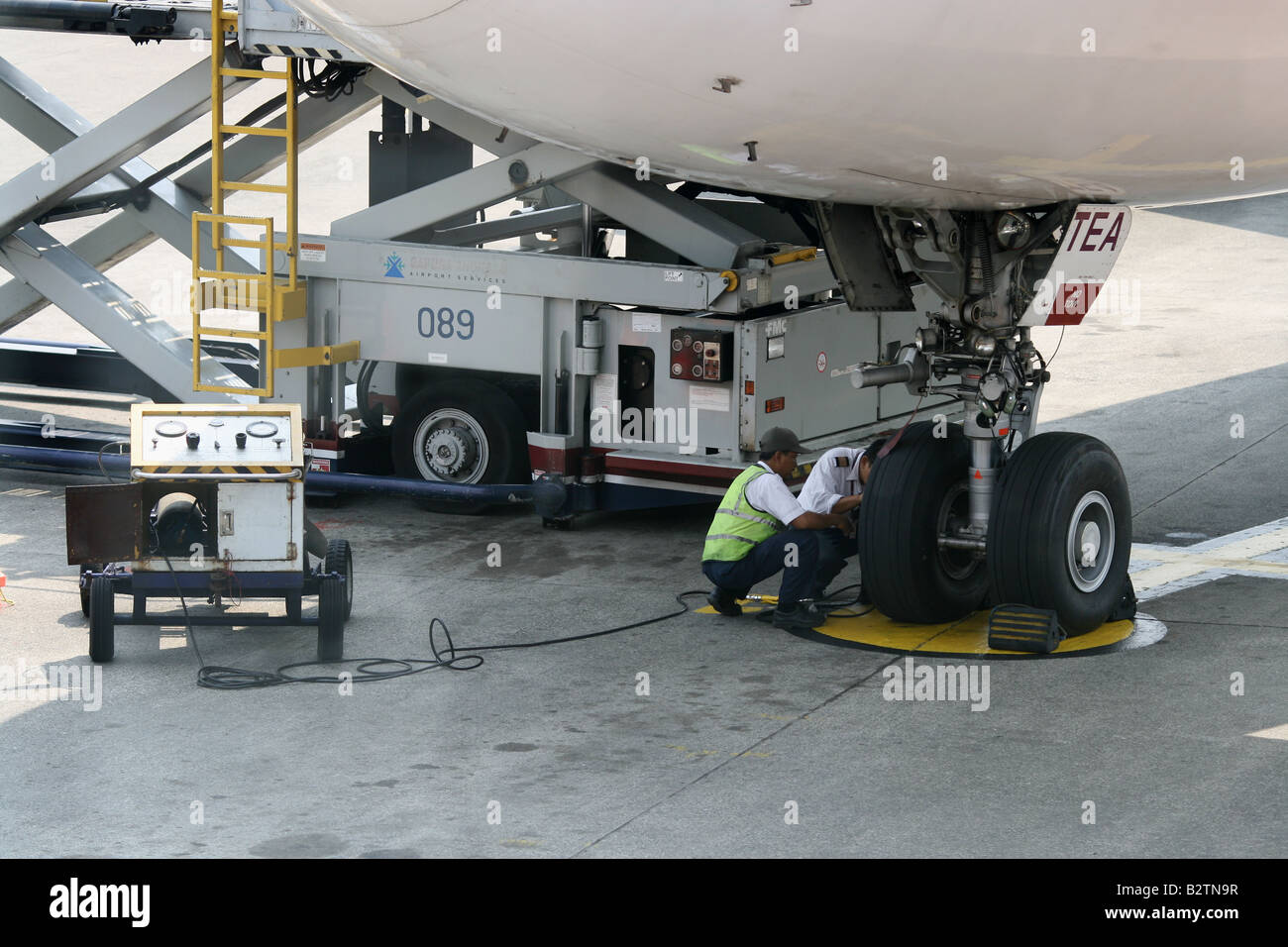 Airplane maintenance crew checking plane tires Soekarno Hatta