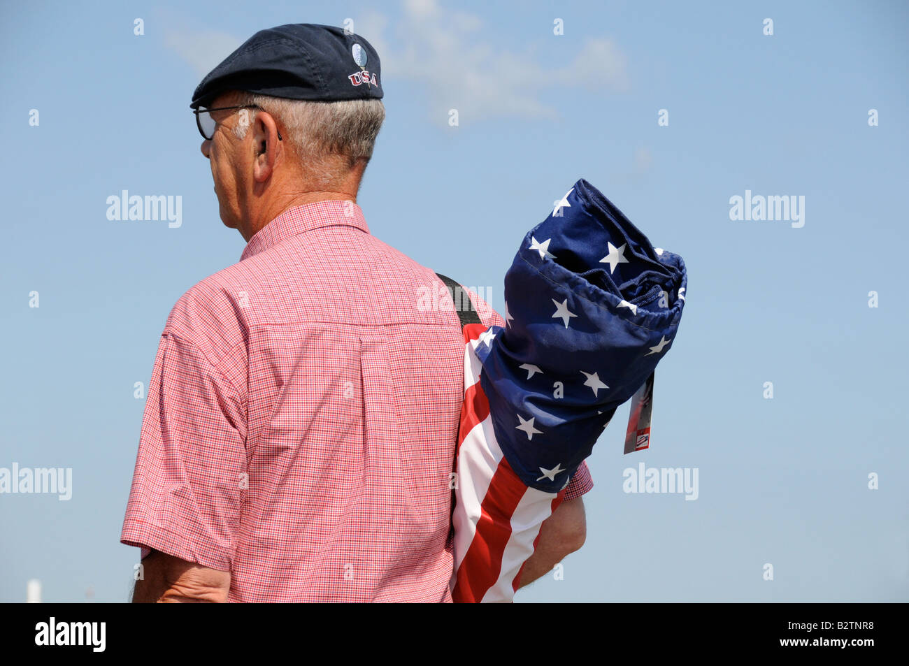 Middle aged man with patriotic shoulder pack containing folding chair. Stock Photo