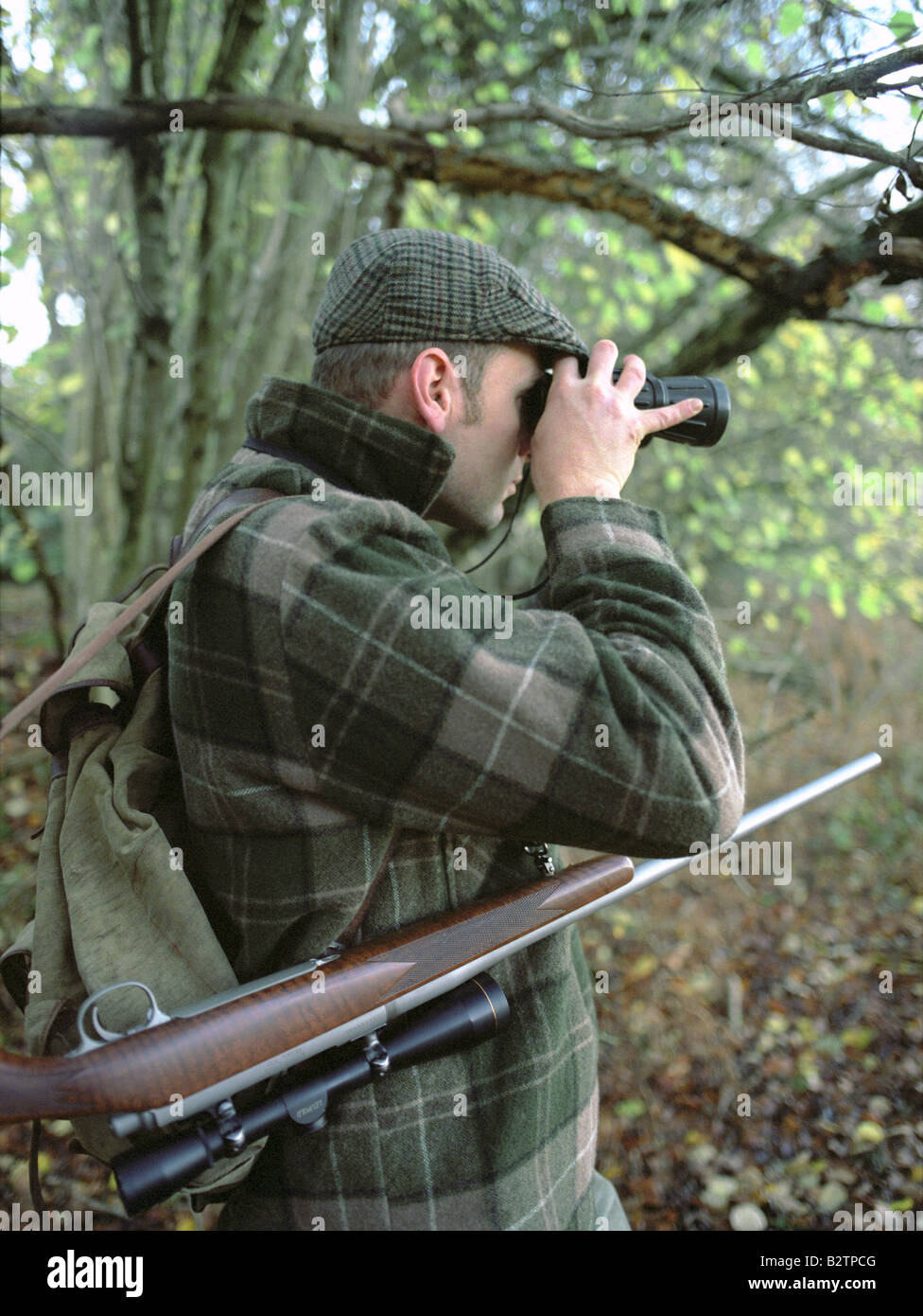 Deer Stalker with Binoculars & Rifle. Stock Photo