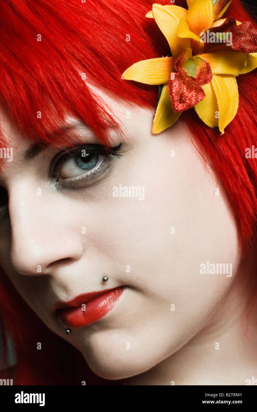 Headshot portrait of a young goth girl with dyed red hair. Stock Photo