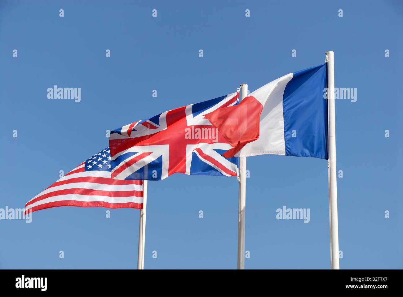 National flags of UK, USA and France against blue sky Stock Photo