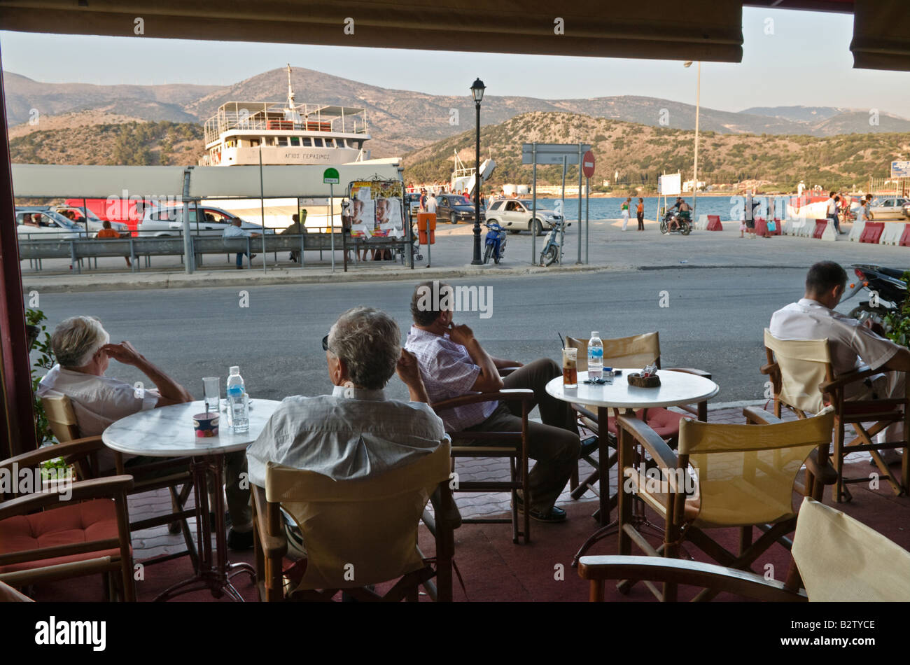 Locals watching the arrival of the early evenung ferry from Lixouri from a waterfront cafe in Argostoli Kefalonia Greece Stock Photo