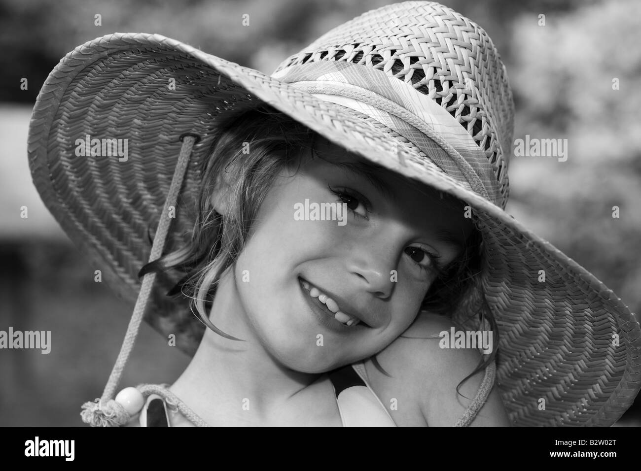 Black and white portrait of smiling young girl wearing a hat Stock