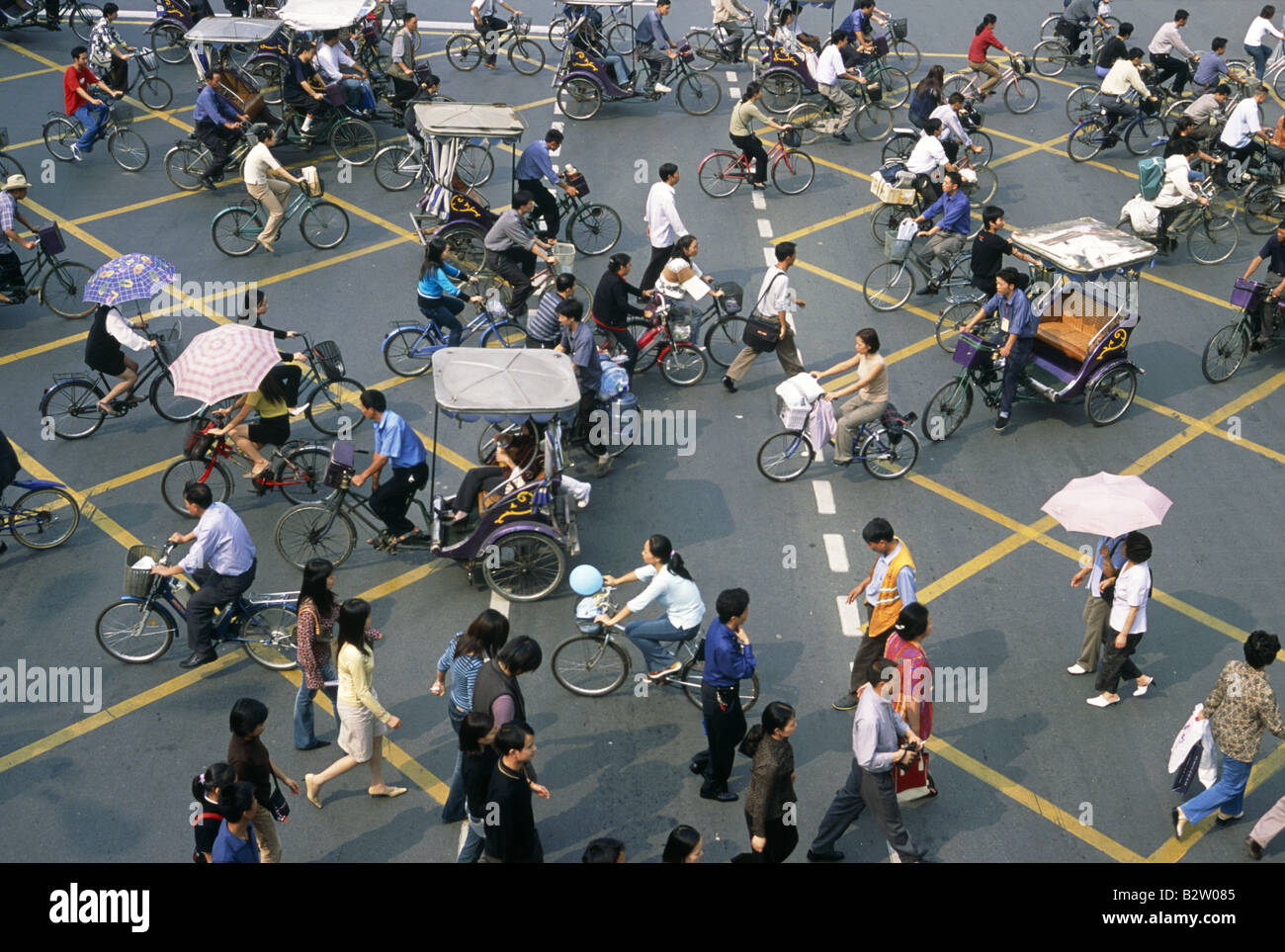 View from height over road intersection yellow lines painted Bicycles pedestrians people Two way traffic CHENGDU SICHUAN CHINA Stock Photo