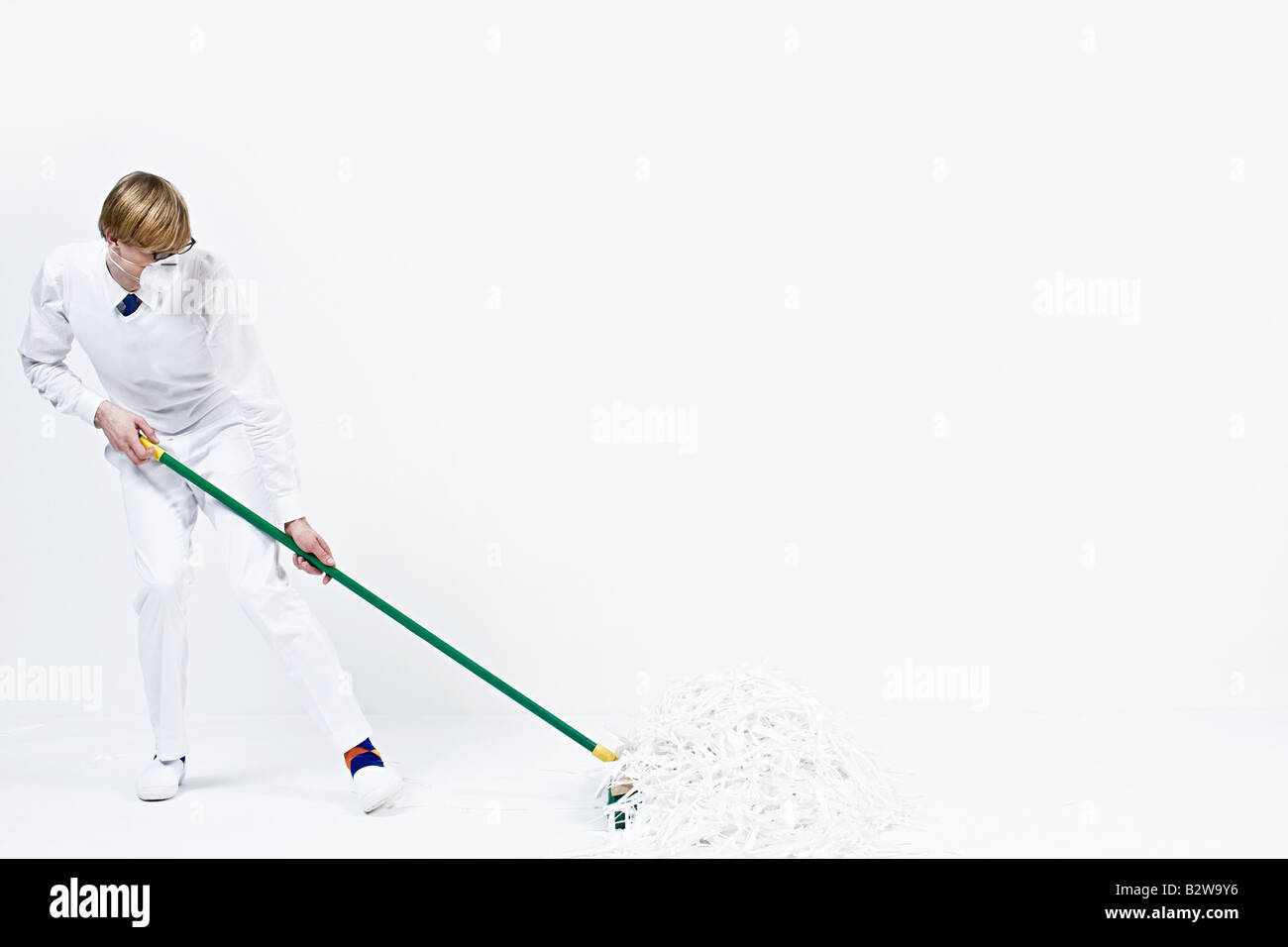 A man sweeping up shredded paper Stock Photo Alamy