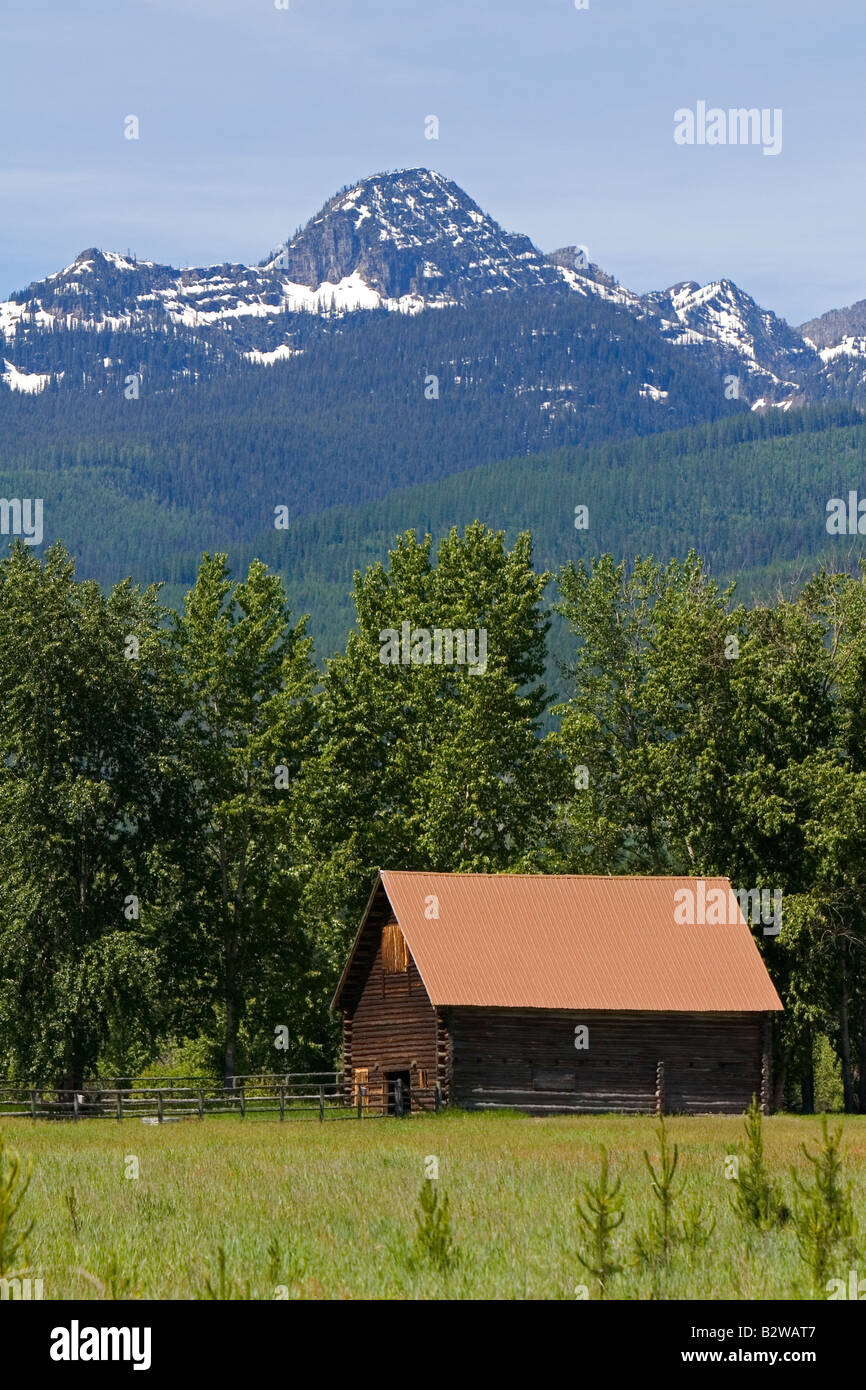 Log barn below the Mission Mountains north of Missoula Montana Stock Photo