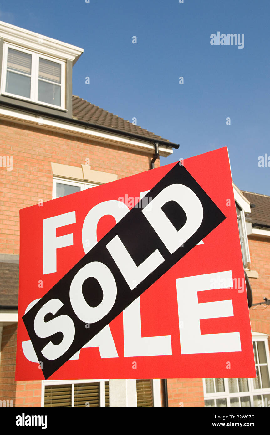 Sold sign and house Stock Photo - Alamy