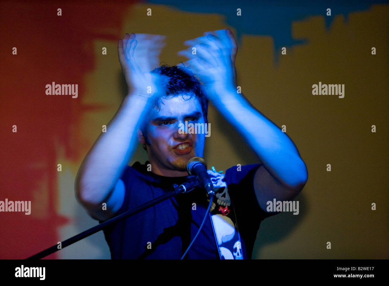 Young man playing guitar and singing in a rock group Stock Photo