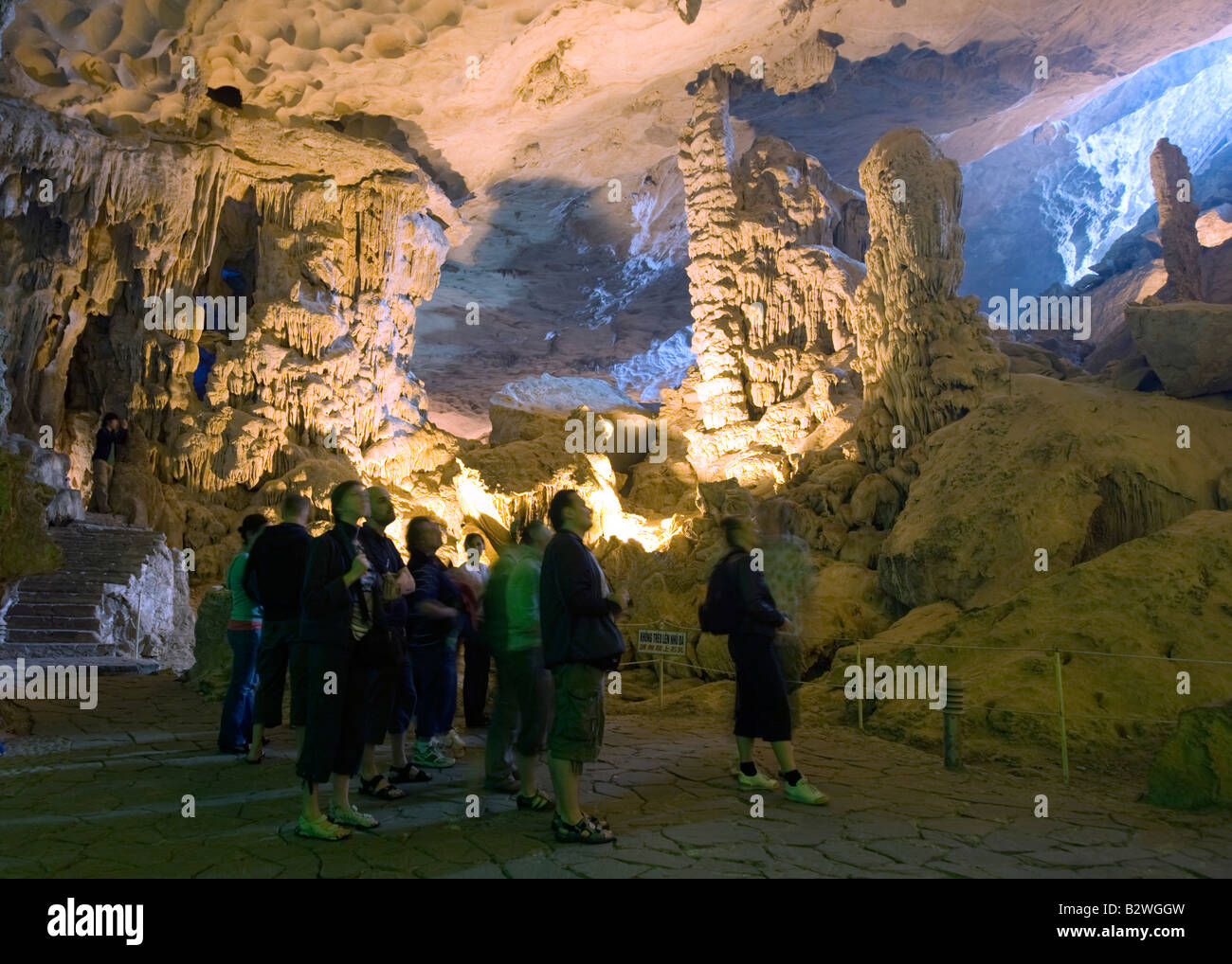 Visitors walk through Hang Sung Sot or Amazing Cave a popular tourist spot in Halong Bay Vietnam Stock Photo