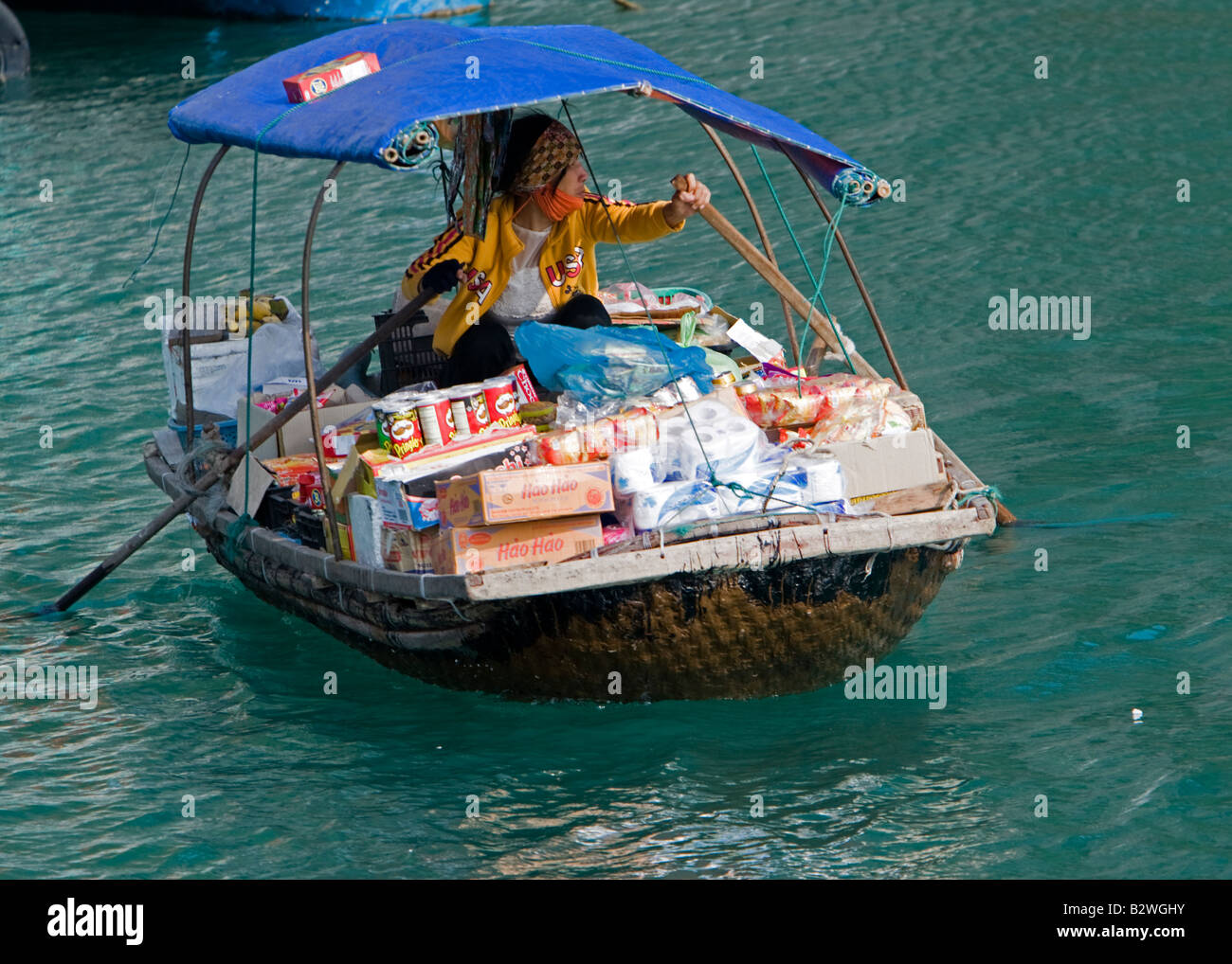 Drink snack hat vendor rowing boat Halong Bay Vietnam Stock Photo