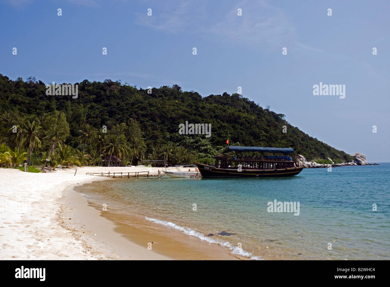 Palm trees and boat sandy beach Cham Island off historic Hoi An Vietnam Stock Photo