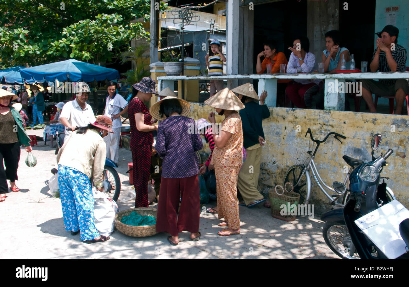 Conical hat women buy shellfish village Cham Island off historic Hoi An Vietnam Stock Photo