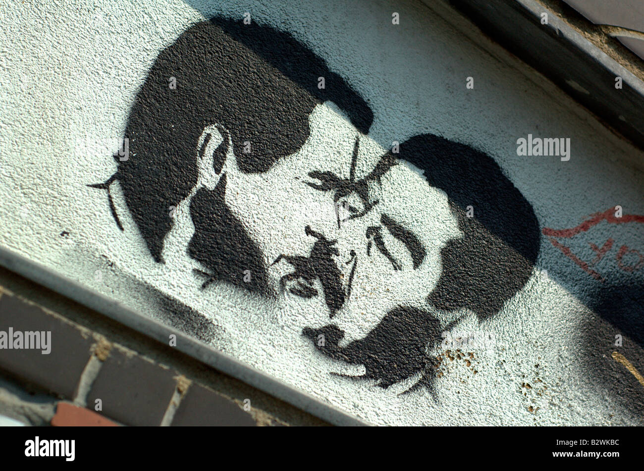 Humorous graffiti depicting George W. Bush and Saddam Hussein sharing a kiss, found on ethnically diverse Brick Lane in London. Stock Photo