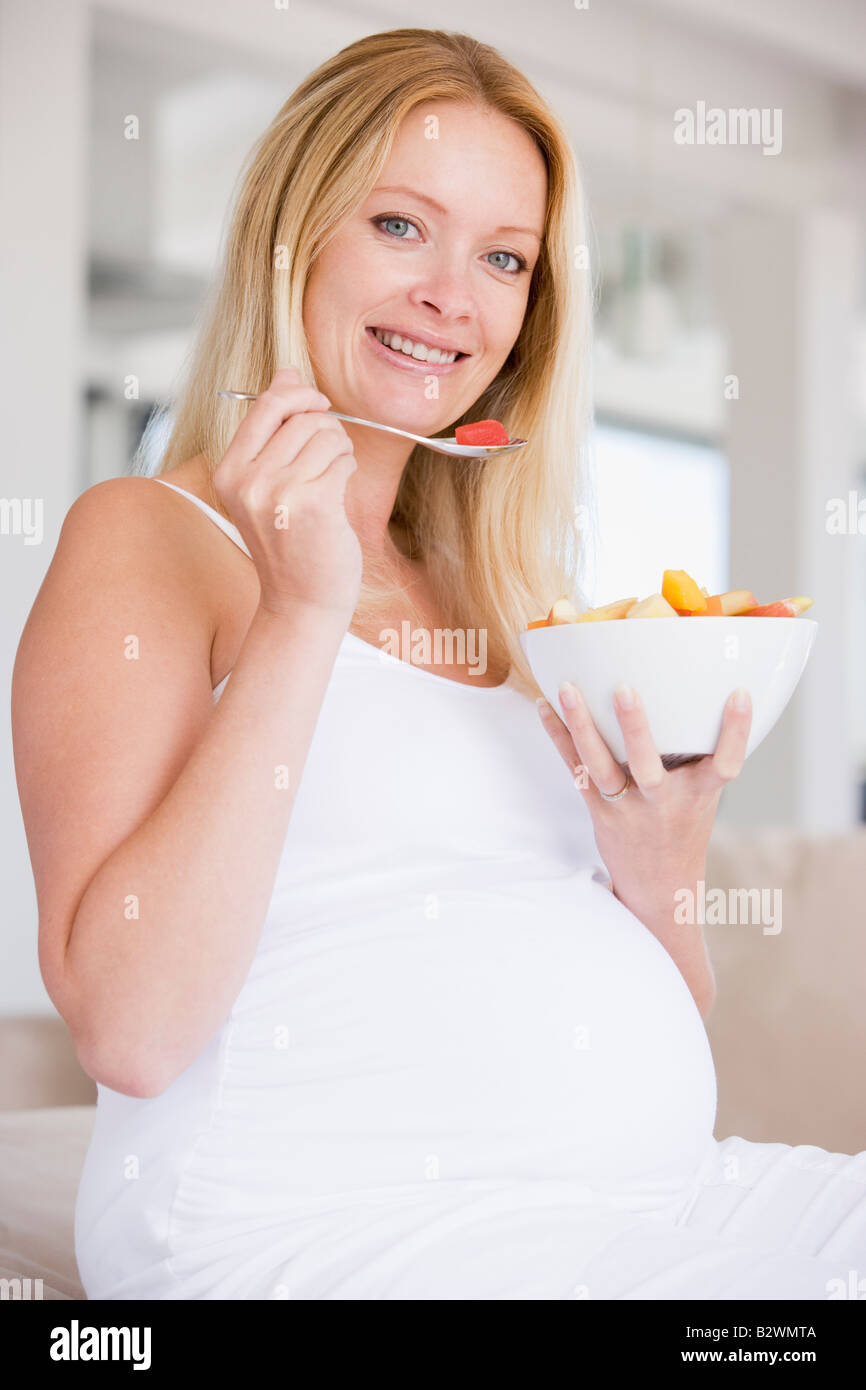 Pregnant woman with bowl of fruit salad smiling Stock Photo Alamy