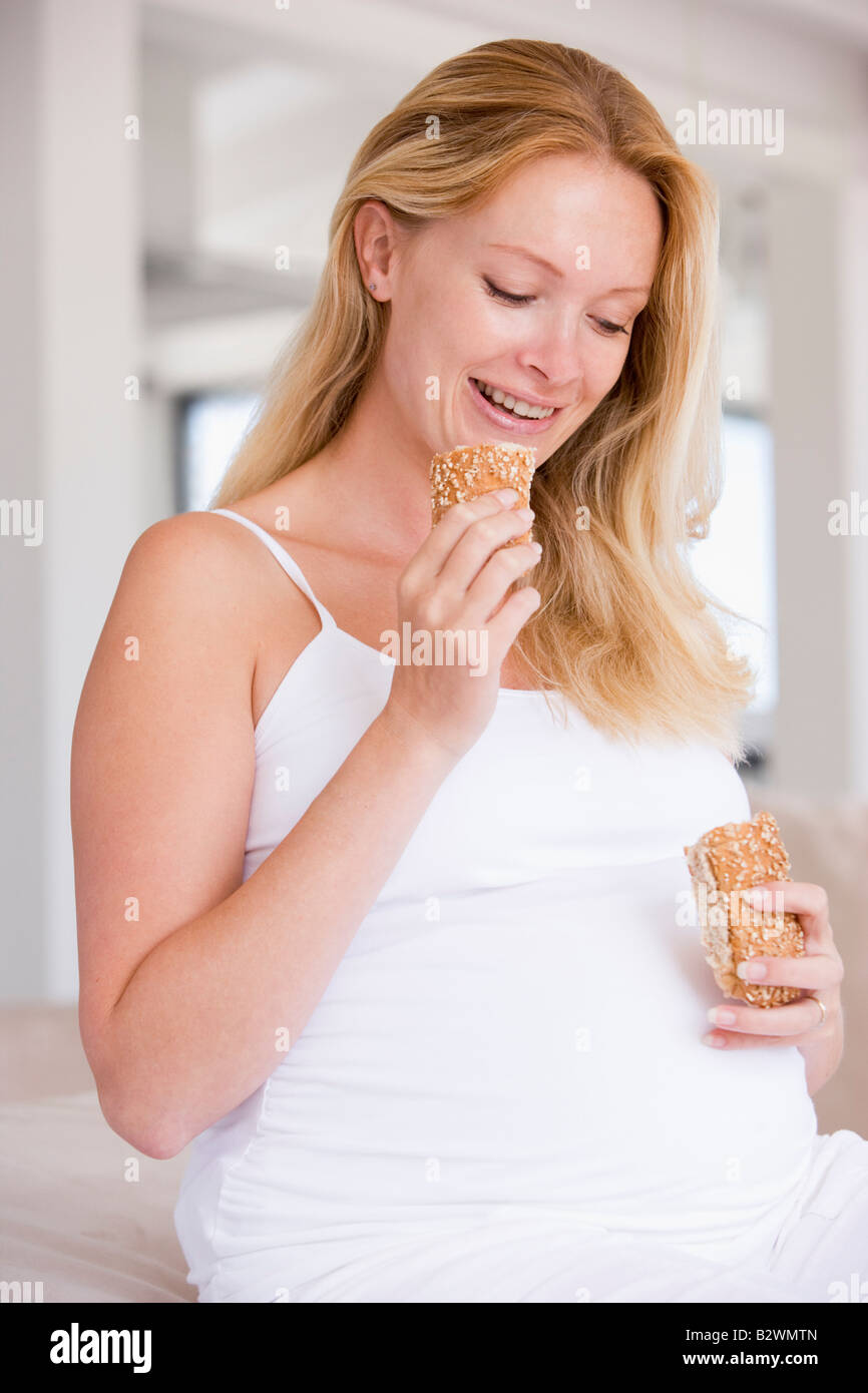 Pregnant woman eating bread and smiling Stock Photo Alamy