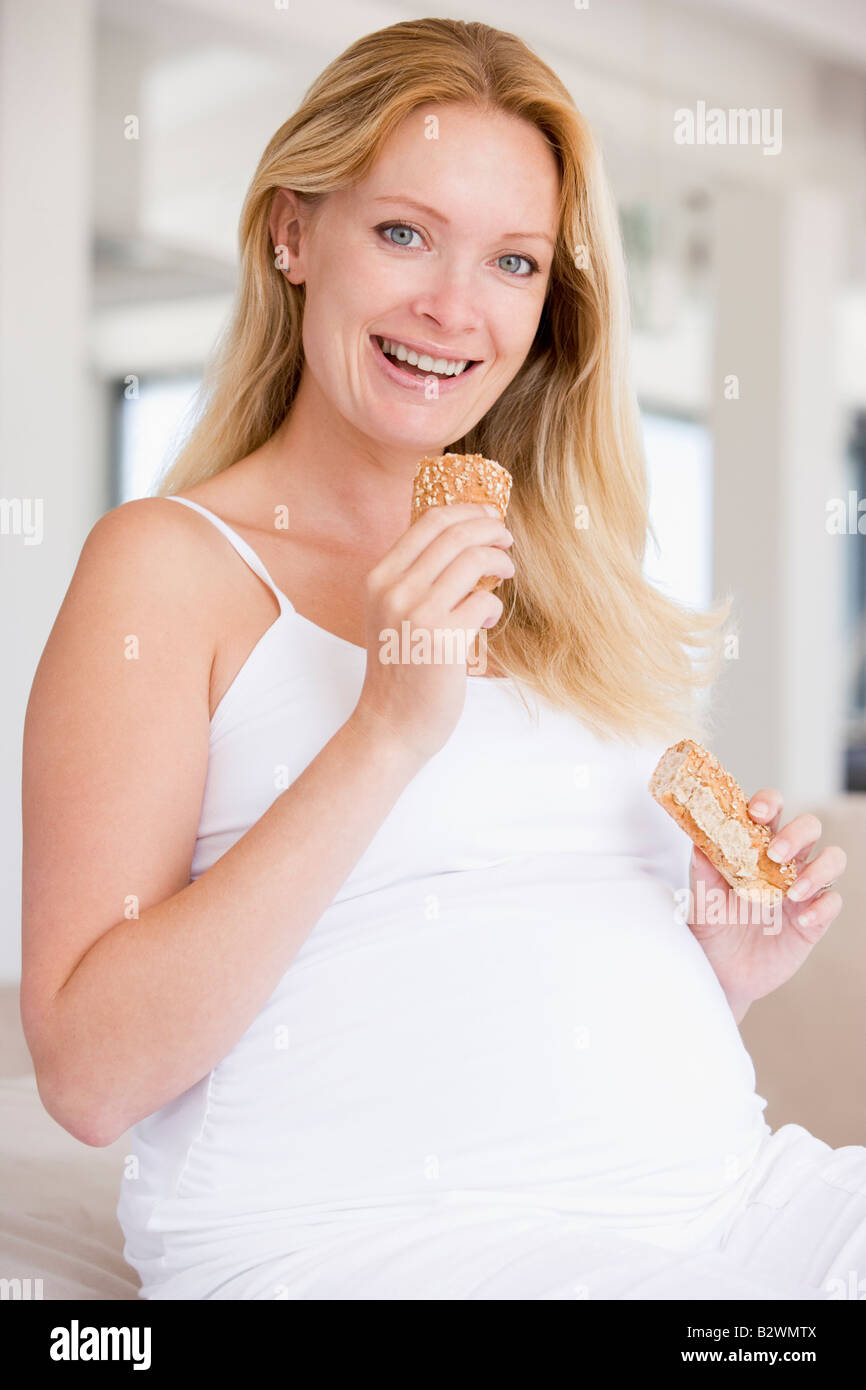 Pregnant woman eating bread and smiling Stock Photo Alamy