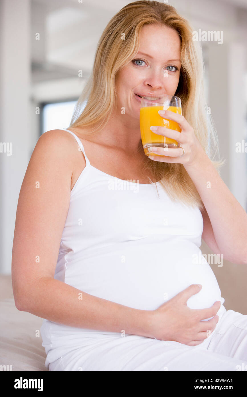 Pregnant woman with glass of orange juice Stock Photo - Alamy