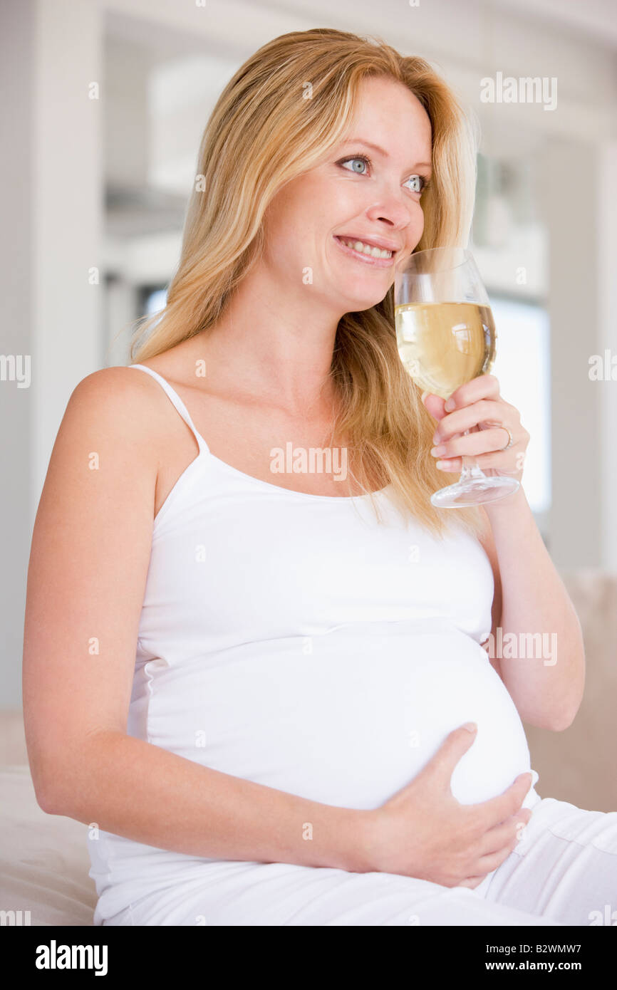 Pregnant woman with glass of white wine smiling Stock Photo Alamy