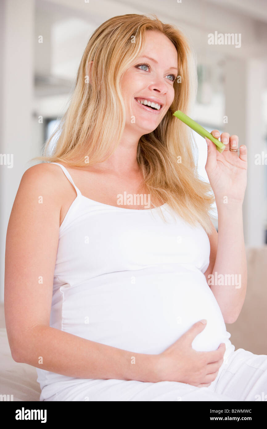 Pregnant woman eating celery and smiling Stock Photo Alamy