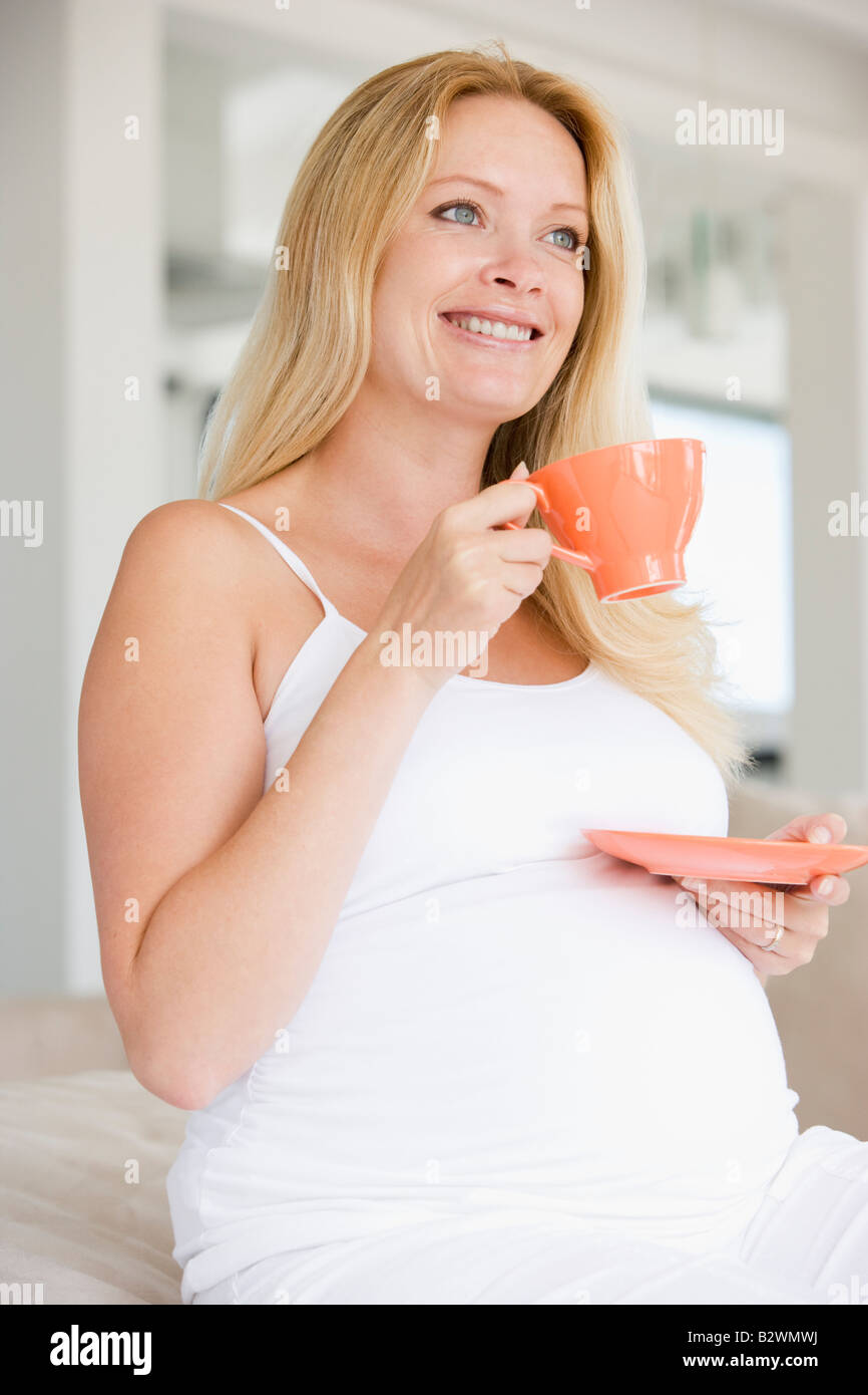 Pregnant woman with cup of tea smiling Stock Photo - Alamy