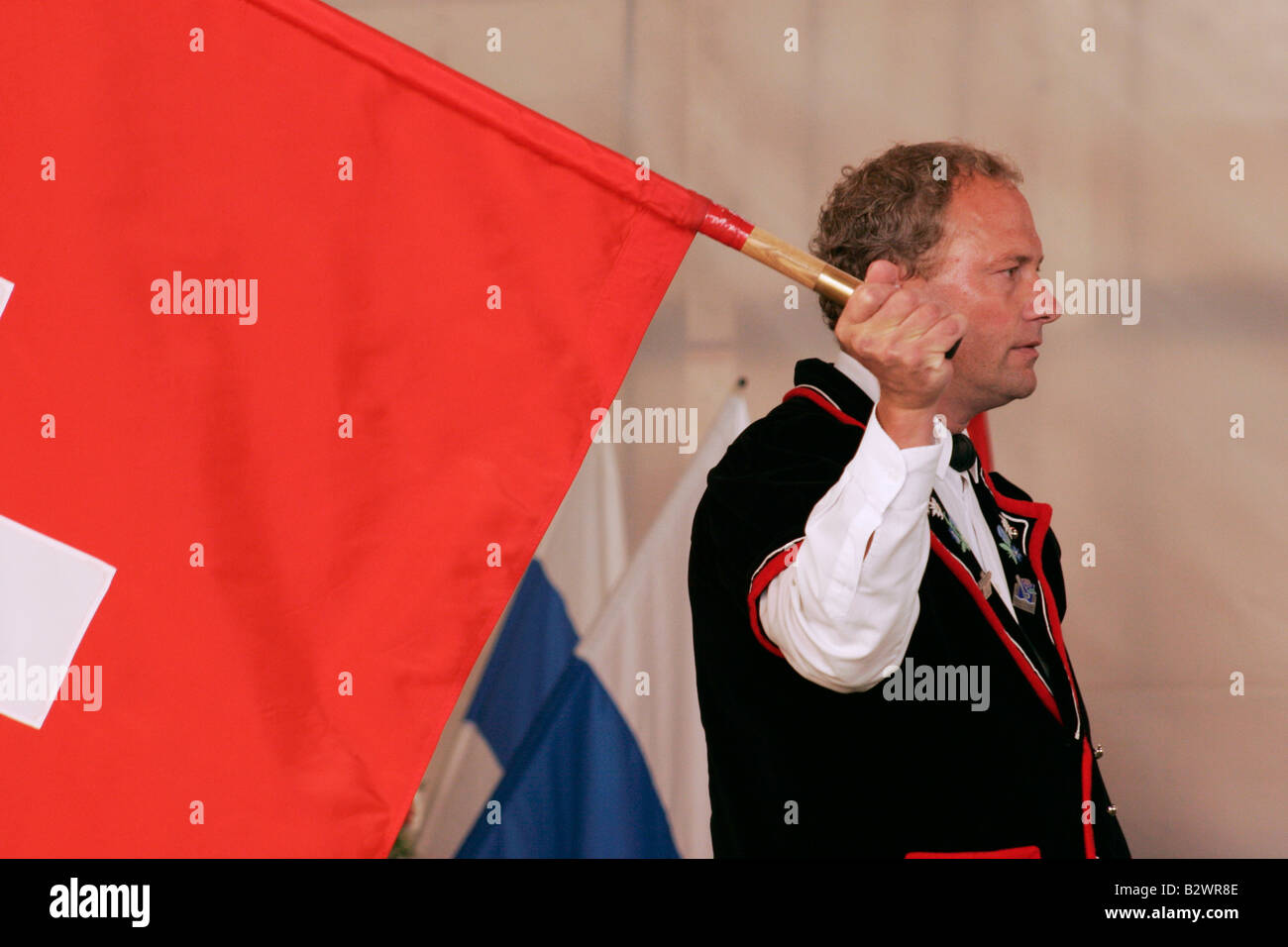 Swiss man in traditional costume competes in flag throwing during Jodlerfest in Malters, near Lucerne, Central Switzerland Stock Photo