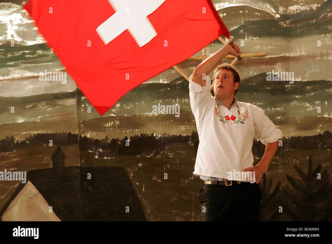 Swiss man in traditional costume competes in flag throwing during Jodlerfest in Malters, near Lucerne, Central Switzerland Stock Photo
