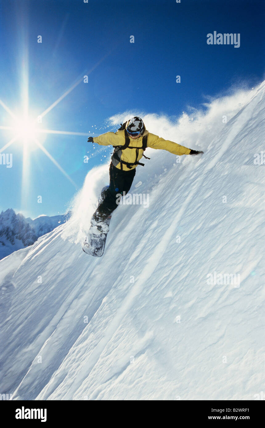 Snowboarder coming down hill Stock Photo