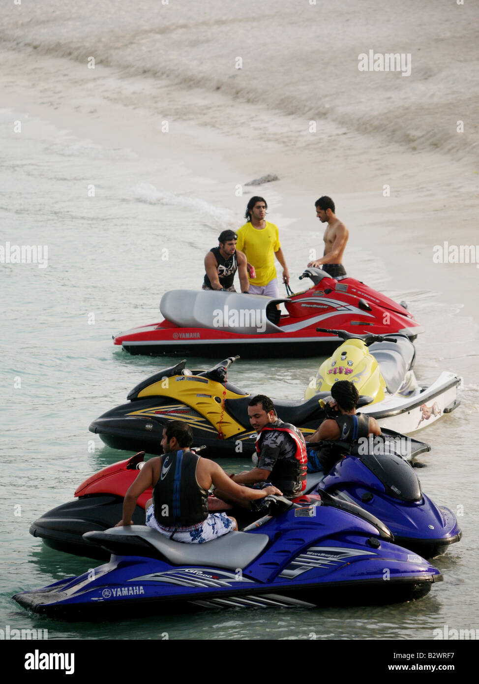 Jet skiers rest and chat on their jet skis along the corniche in Abu Dhabi Stock Photo