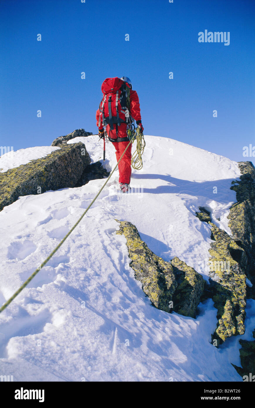Mountain climber walking on snowy mountain Stock Photo