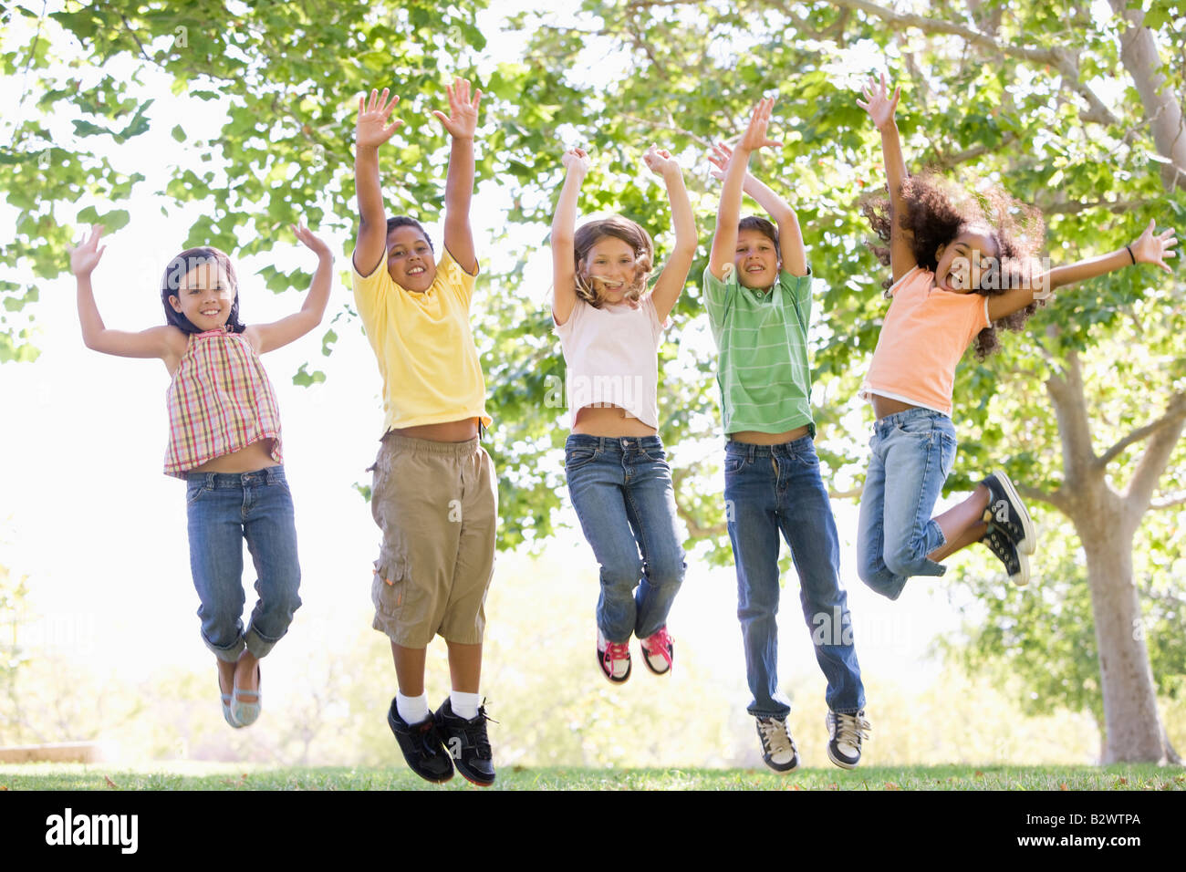 Group of five happy children jumping outdoors., Group of fi…