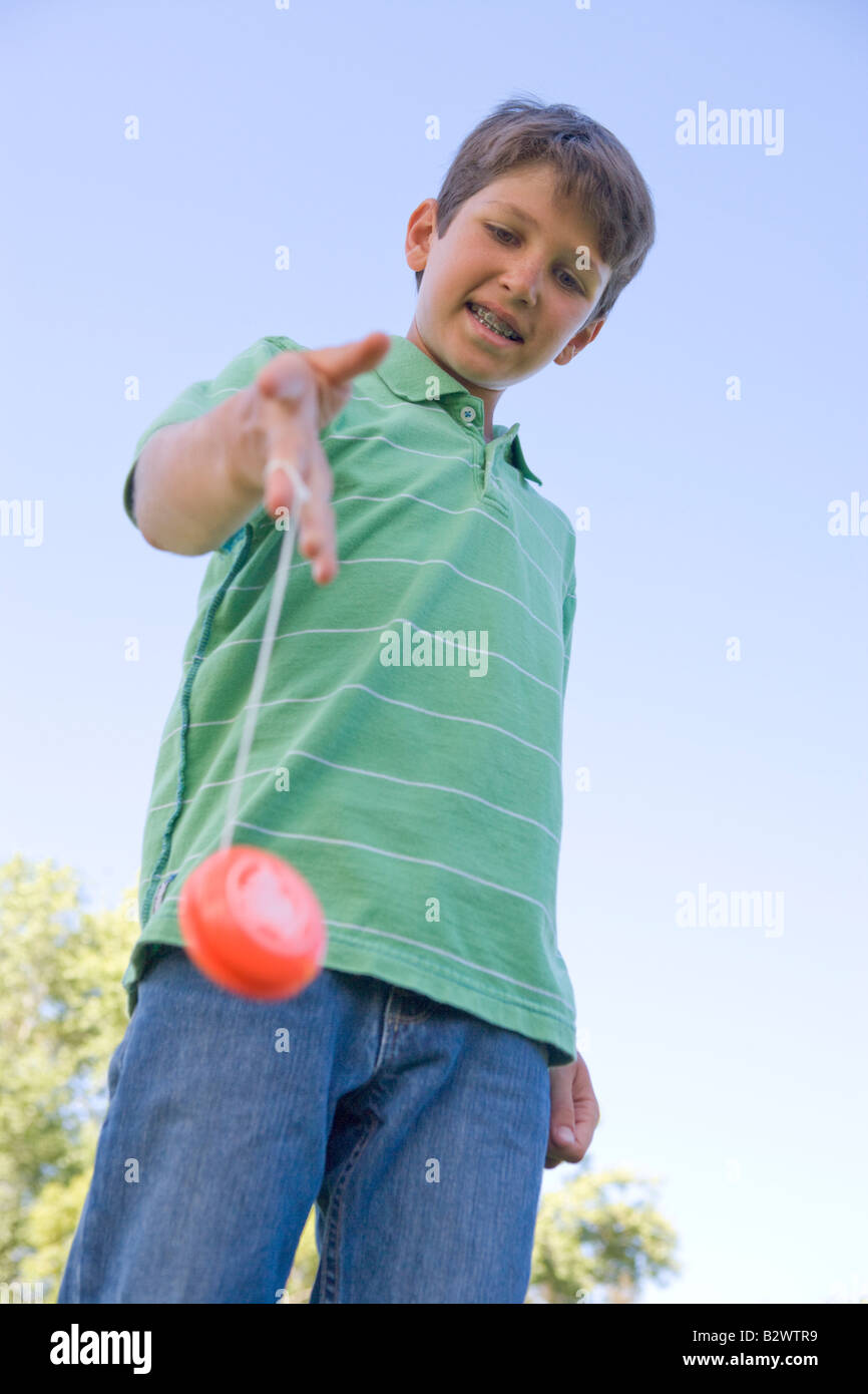 Young boy using yo yo outdoors smiling Stock Photo - Alamy