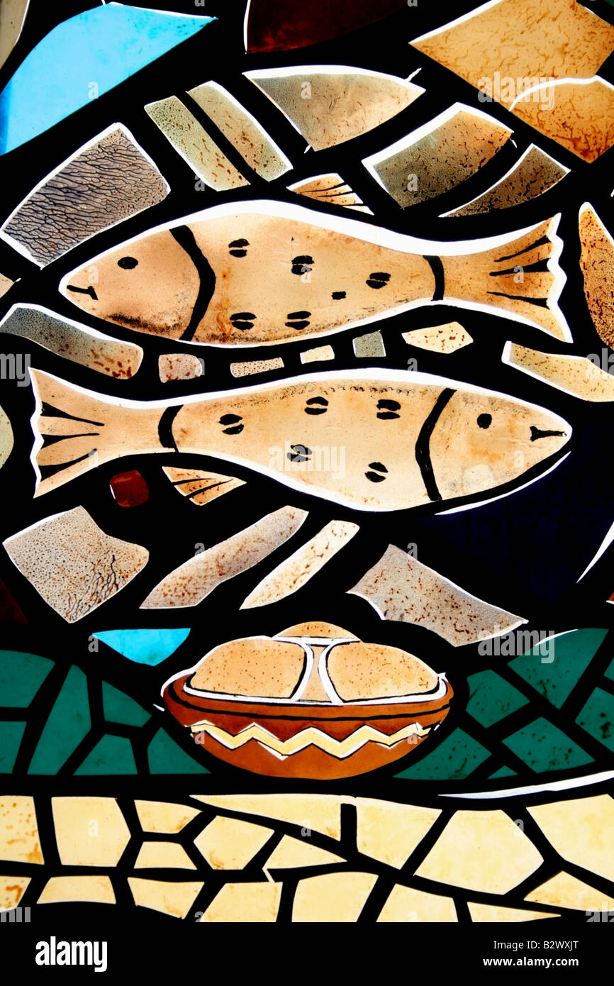 Stain glass window depicting the feeding of the five thousand with fish and bread , Togo , West Africa Stock Photo