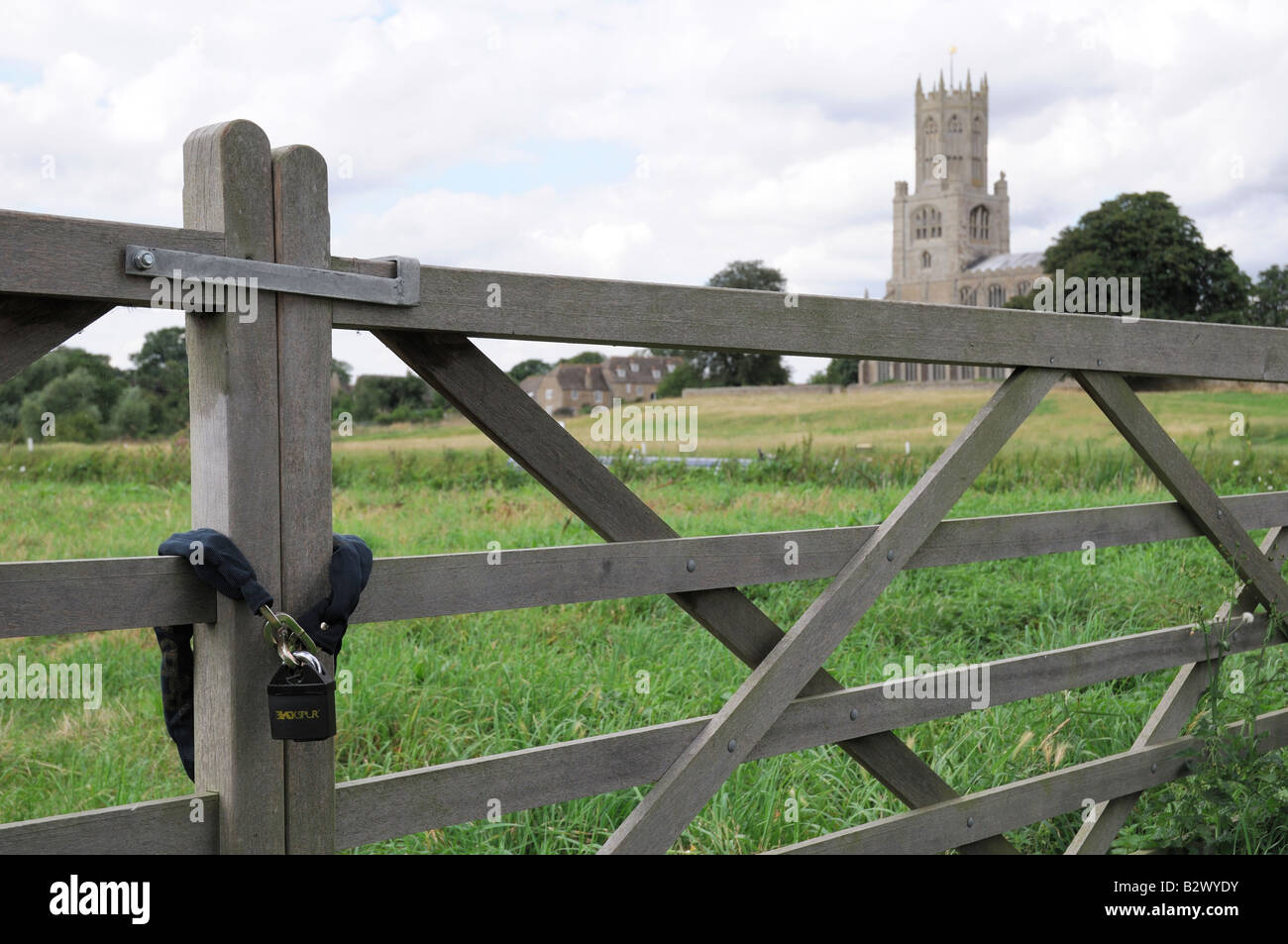 Fotheringhay Church and locked wooden bar gate Stock Photo